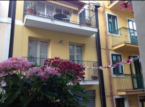 ein Gebäude mit rosa Blumen davor in der Unterkunft Avaja Daria's apartment Taormina in Taormina