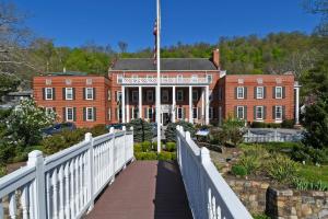 un puente frente a un gran edificio de ladrillo rojo en The Country Inn of Berkeley Springs, en Berkeley Springs