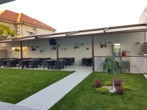a patio with black tables and chairs and grass at Turquoise Boutique Mamaia Nord in Mamaia Sat/Năvodari