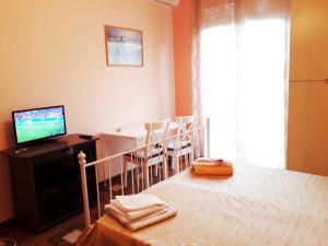 a bedroom with a bed and a table with chairs at Stella Marina in Giardini Naxos