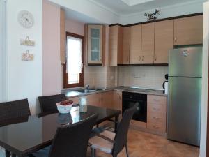a kitchen with a table and a stainless steel refrigerator at Evgenia Maisonette in Ierissos