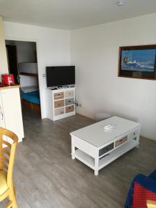 een woonkamer met een tv en een witte salontafel bij Ty Avel in Quiberon
