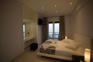 a bedroom with a bed and a large window at Mare Studios Exclusive in Plomarion