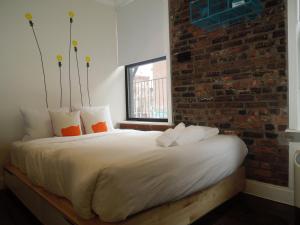 a bed in a room with a brick wall at East Village Hotel in New York