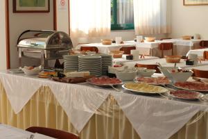 einen Tisch mit Teller mit Lebensmitteln darüber in der Unterkunft Hotel Eden in Lignano Sabbiadoro