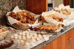 a buffet with baskets of pastries and other foods on a counter at Hotel Eden in Lignano Sabbiadoro