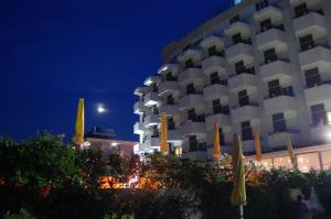 a hotel building with yellow umbrellas in front of it at Hotel David in Cesenatico