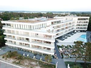 an overhead view of a large white building with a pool at DUNE Apartments in Mielno