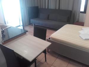 プレベザにあるTeris Appartmentのベッド2台、ソファ、テーブルが備わる客室です。