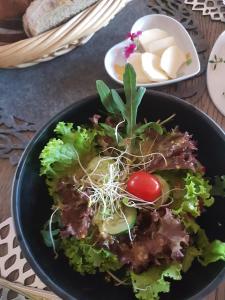 a black plate of food with vegetables and cheese at Mak in Murowana Goślina