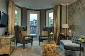 a living room with a couch and chairs and a tv at Hotel Veritas in Cambridge