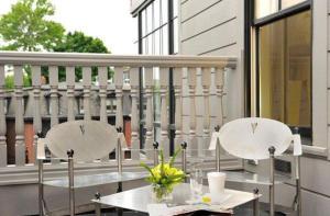 two white chairs and a table on a balcony at Hotel Veritas in Cambridge