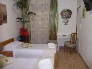a hotel room with a bed, chair, and table at Victoria in Catania