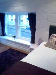 a bedroom with a bed and a window at Finn MacCools Public House & Guest Inn in Bushmills