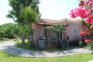 a small pink house with trees and pink flowers at Studio Aspa in Skala Eresou