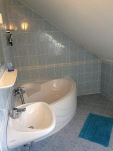 uma casa de banho com uma banheira e um lavatório em Mary Apartment em Siófok