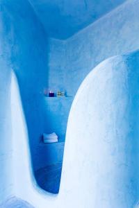 Habitación azul con baño con bañera. en Windmill Villas, en Imerovigli