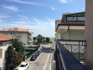 uma vista para a rua a partir de uma varanda de um edifício em Residence Europa em Alba Adriatica