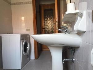 a bathroom with a sink and a washing machine at Residence Europa in Alba Adriatica