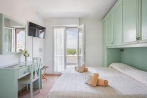 sypialnia z łóżkiem, biurkiem i oknami w obiekcie Hotel Pacific w mieście Cattolica