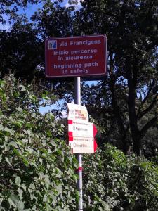una señal en un poste delante de algunos árboles en Agriturismo San Pietro en Castiglione dʼOrcia