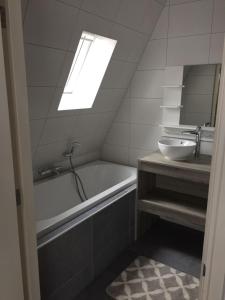 a bathroom with a sink and a tub and a mirror at Appartementen De Helling 44 in Heeg +66 photos