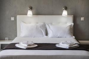a bed with white pillows and two towels on it at Ponti Beach Hotel in Vasiliki