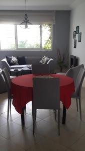 a living room with a red table and chairs at Residence les Pins in Rabat