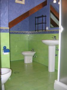 La salle de bains est pourvue de 2 lavabos et de 2 toilettes. dans l'établissement Apartamentos La Corraliza, à Totero