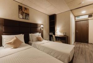 Säng eller sängar i ett rum på Helix Hotel