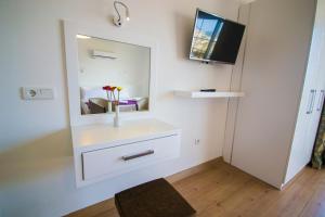La salle de bains est pourvue d'une commode blanche et d'un miroir. dans l'établissement Kelebek Hotel, à Kalkan