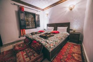 1 dormitorio con 1 cama grande con almohadas rojas en Riad Marwa Marrakech en Marrakech