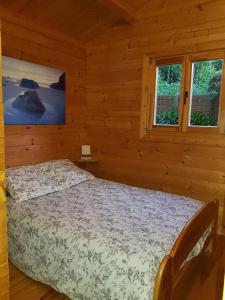 a bedroom with a bed in a log cabin at Le Chalet de Valentine & Laurent in Olmiccia