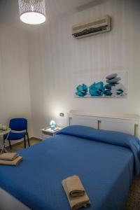 a bedroom with a blue bed with a blue blanket at Home OLY in Gragnano
