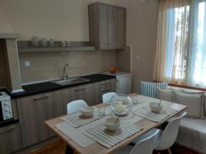 a kitchen with a wooden table with chairs and a sink at Skiron House in Skala Kallirachis