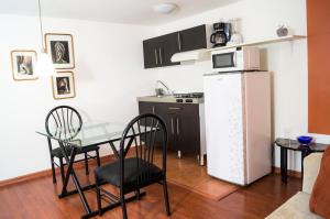 a kitchen with a table and a white refrigerator at Suite 4B Bazzar, Garden House, Welcome to San Angel in Mexico City