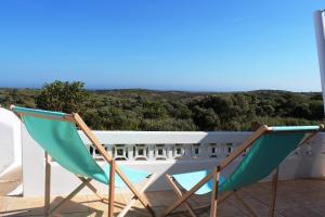 two chairs sitting on top of a balcony at Trivial Pisão - Casa de Férias, para a sua Família in Raposeira