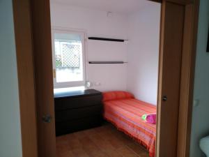 niewielka sypialnia z łóżkiem i oknem w obiekcie Apartament LUISA w Lloret de Mar