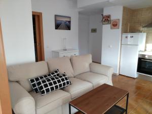 uma sala de estar com um sofá branco e uma mesa em Apartament LUISA em Lloret de Mar