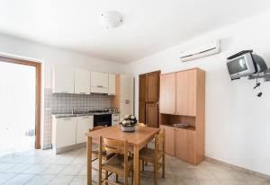 uma cozinha com uma mesa de madeira e uma pequena mesa e cadeiras em Residenza Piccolo Uliveto em San Menaio