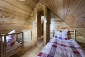 a log cabin with a bed in a room at Domek w sercu Kaszub in Sominy