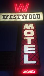 un cartello per un ristorante wii con un'insegna al neon di Westwood Motel a West Yellowstone