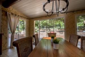 a dining room with a wooden table and chairs at Mas Saint Antoine in Bourg-Saint-Andéol