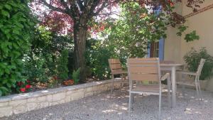 deux chaises assises à une table sous un arbre dans l'établissement Chambres et Tables d'Hotes "Au pres de ma Blonde", à Senouillac