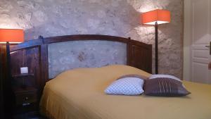 a bedroom with a bed with two pillows and two lamps at Chambres et Tables d'Hotes "Au pres de ma Blonde" in Senouillac