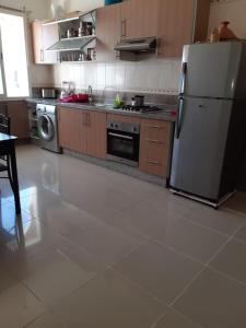 a kitchen with a refrigerator and a dishwasher at Résidence al massirra in Fnidek