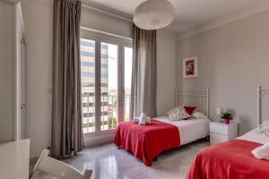 a bedroom with two beds and a large window at Apartment Link BCN Sants in Barcelona