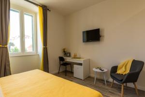 a bedroom with a bed and a desk and a tv at SeaBed Rooms Split in Split