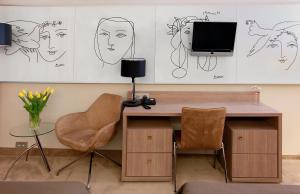 uma secretária com duas cadeiras e uma televisão na parede em Hotel HP Park em Olsztyn