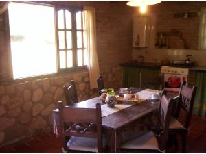 a kitchen with a wooden table with chairs and a tableablish at Cabanas Las Achiras in San Javier